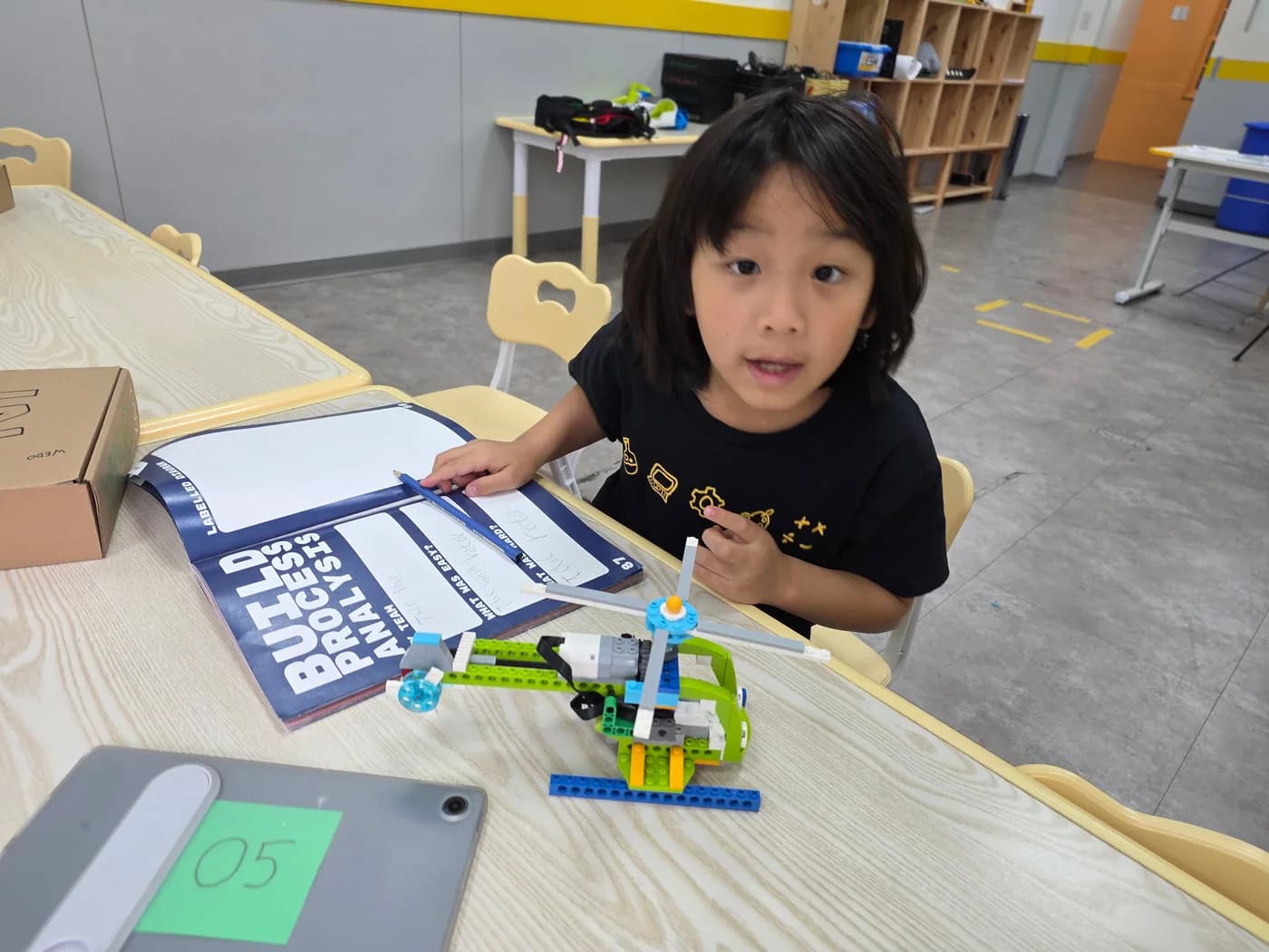 A student combining coding reflection with a hands-on mechanism