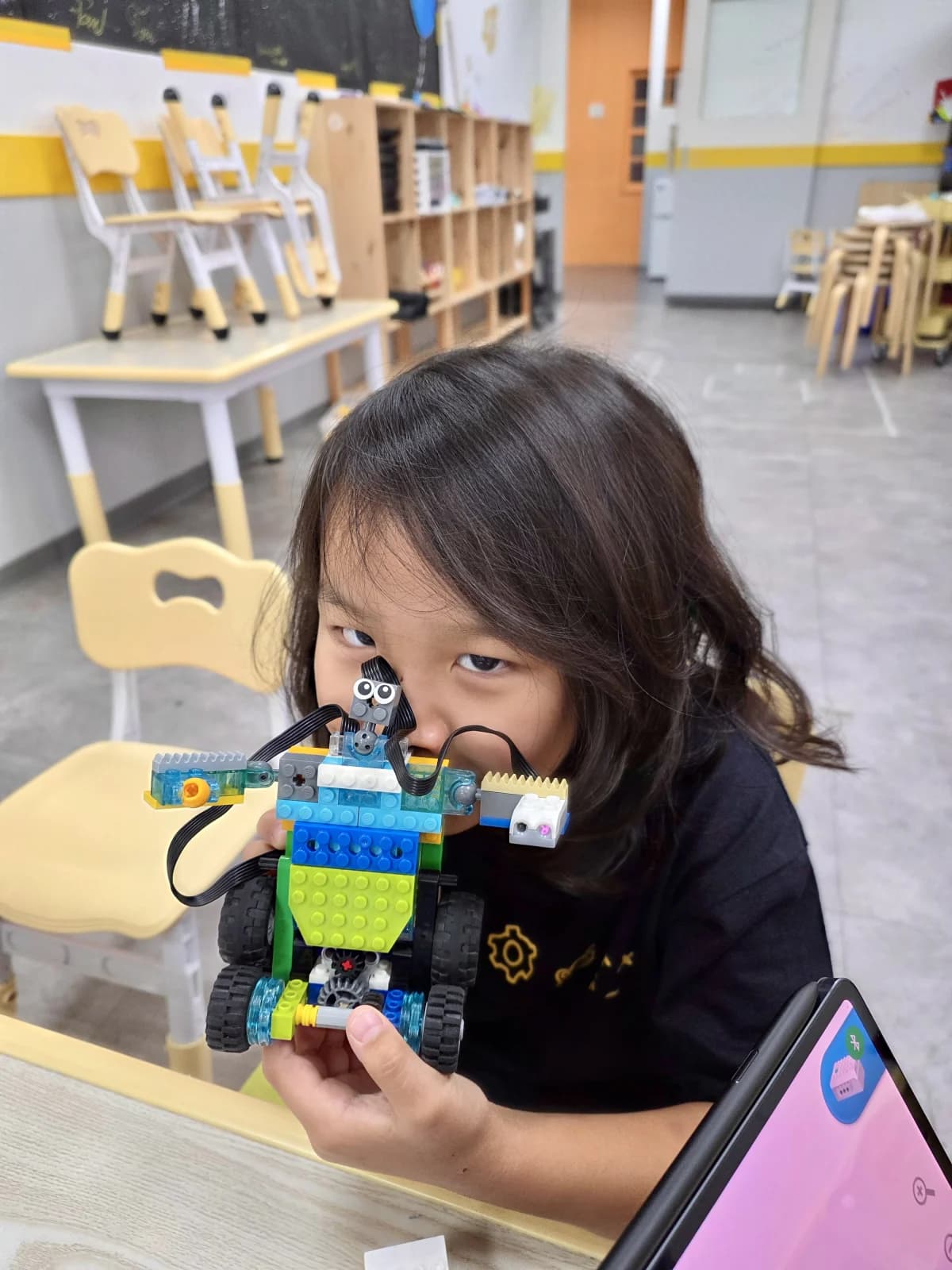 學生展示親手改造的 WeDo 2.0 SmartBot,可看見動作感測器與齒輪傳動