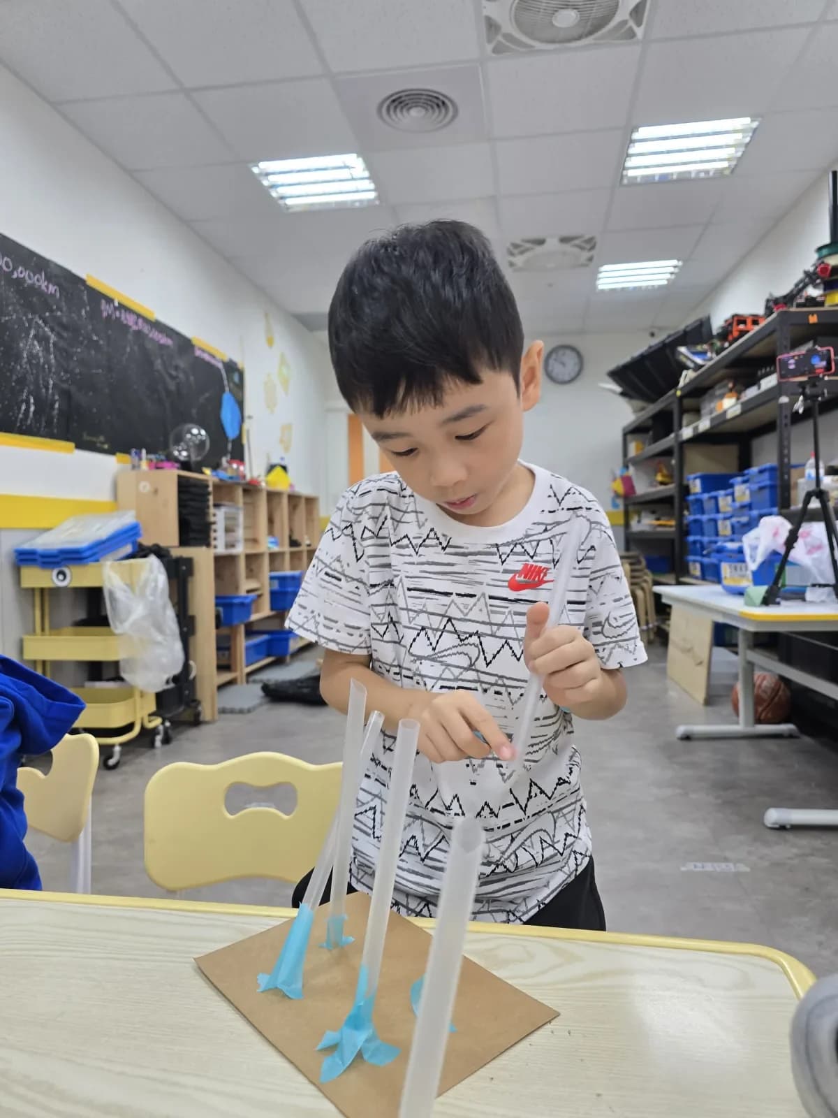 A First Steps student carefully building a tall structure