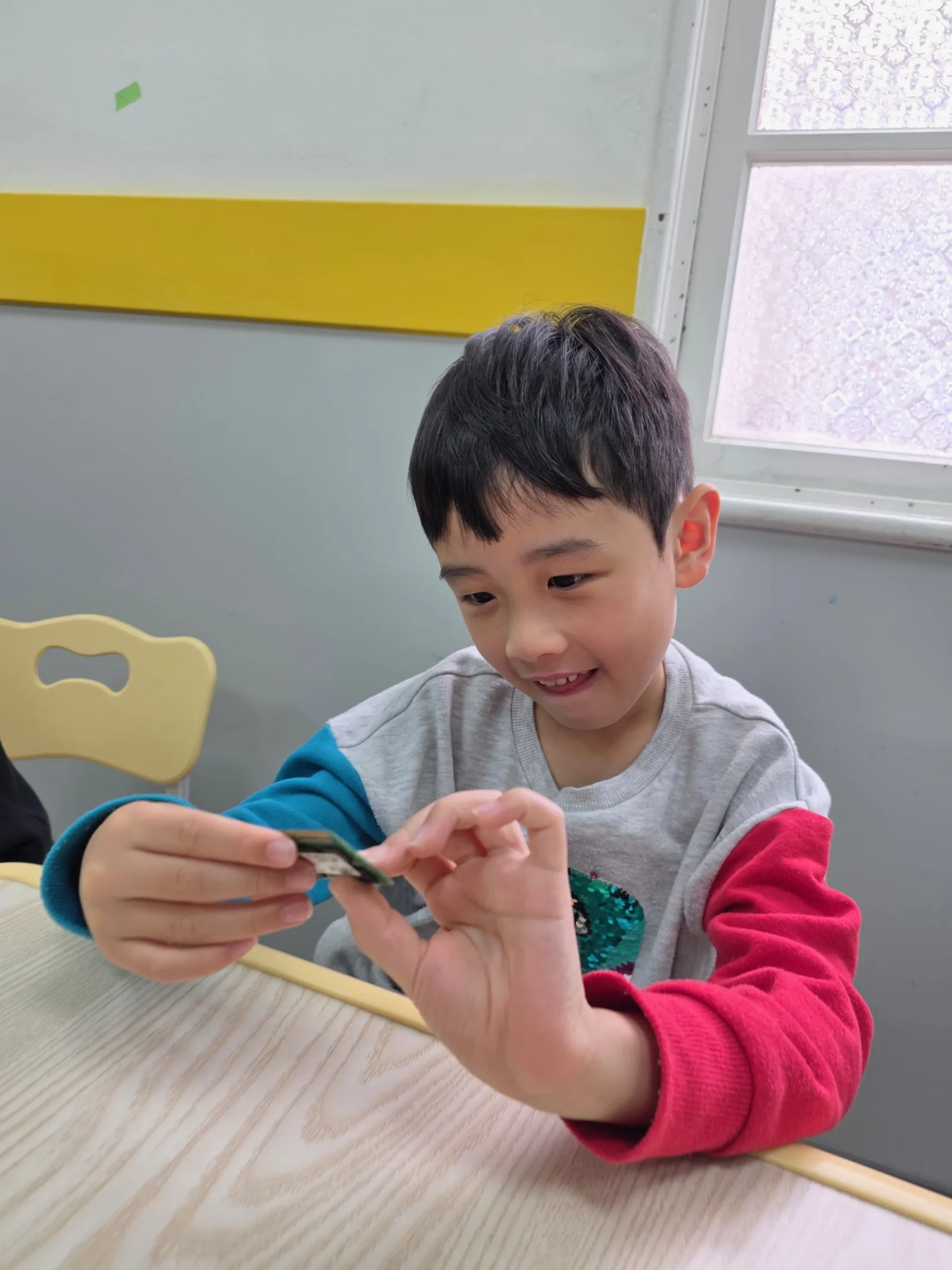 A smiling student examining a circuit board
