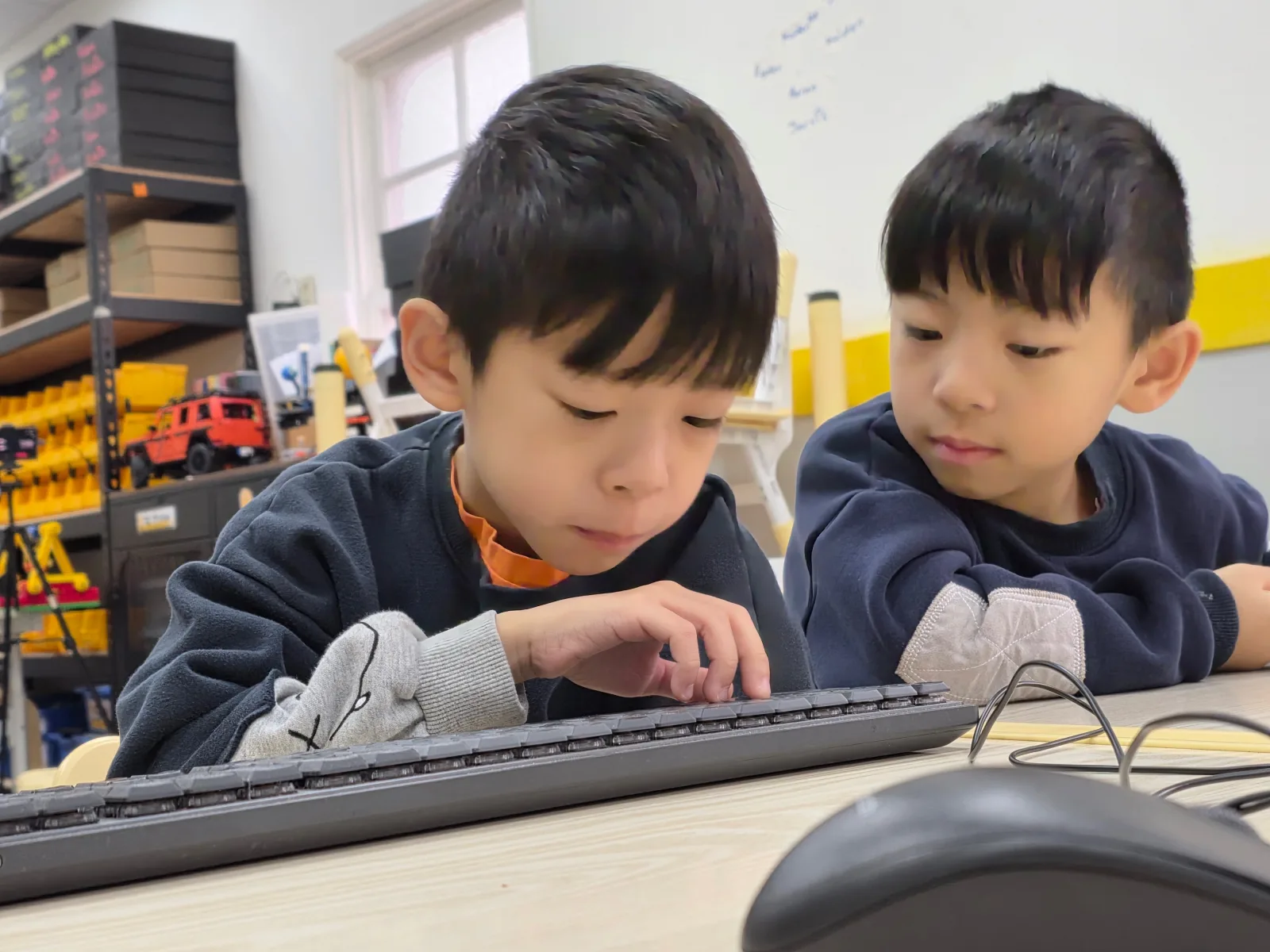 Two children exploring a keyboard together