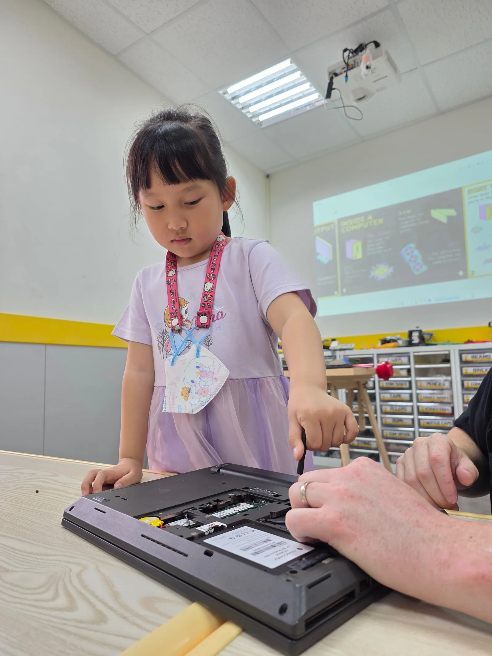 A student independently exploring the inside of a laptop