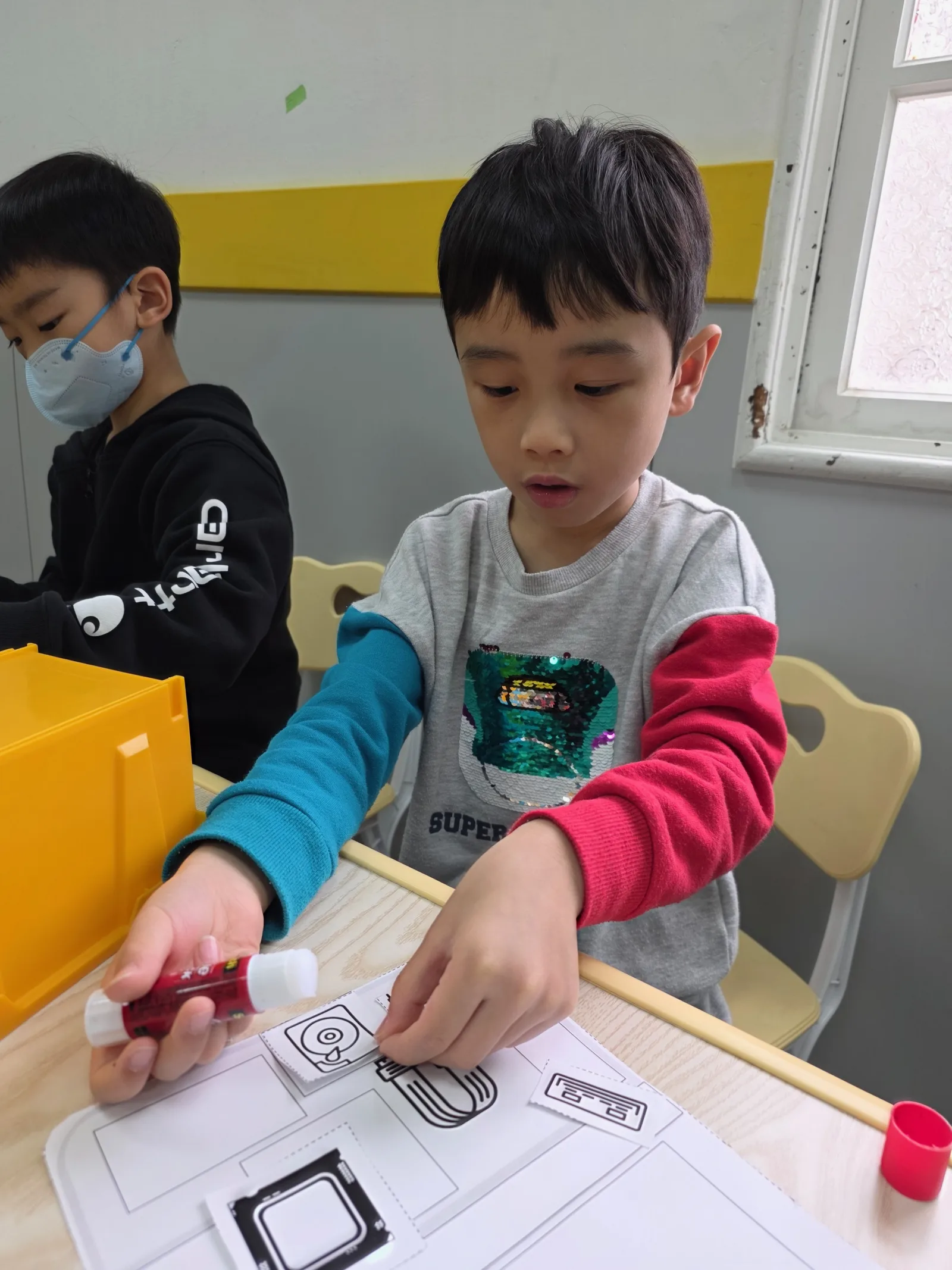 A child turning computer knowledge into a paper model