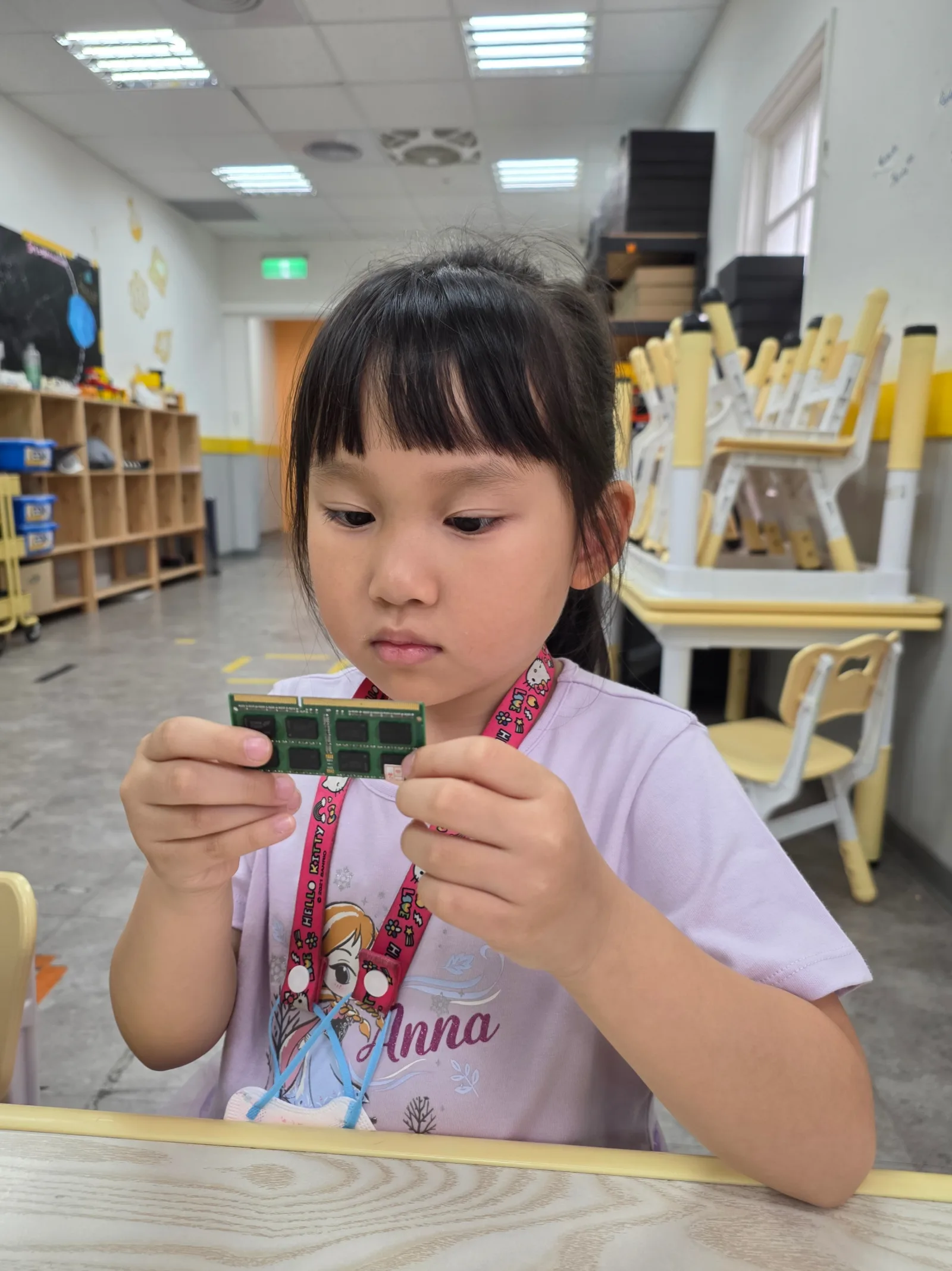 A First Steps student closely examining a computer memory module
