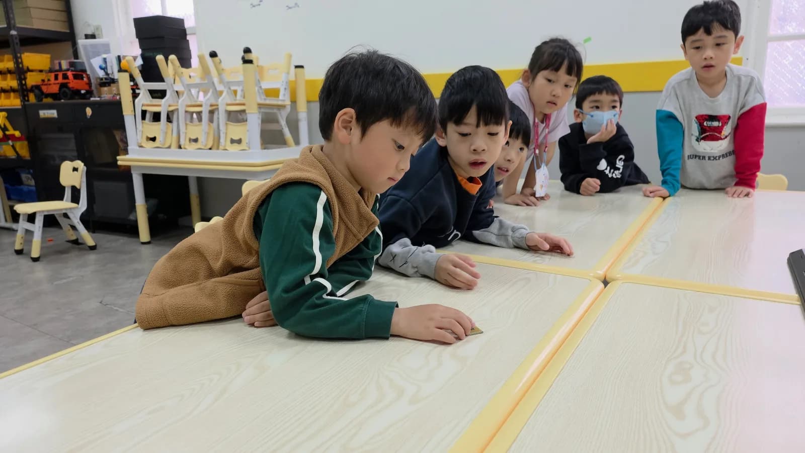 A First Steps group gathering around a tiny computer component