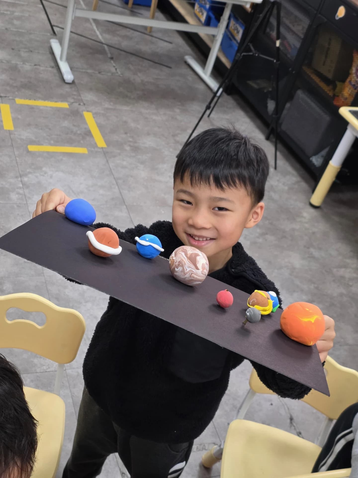 A First Steps student presenting a handmade solar system