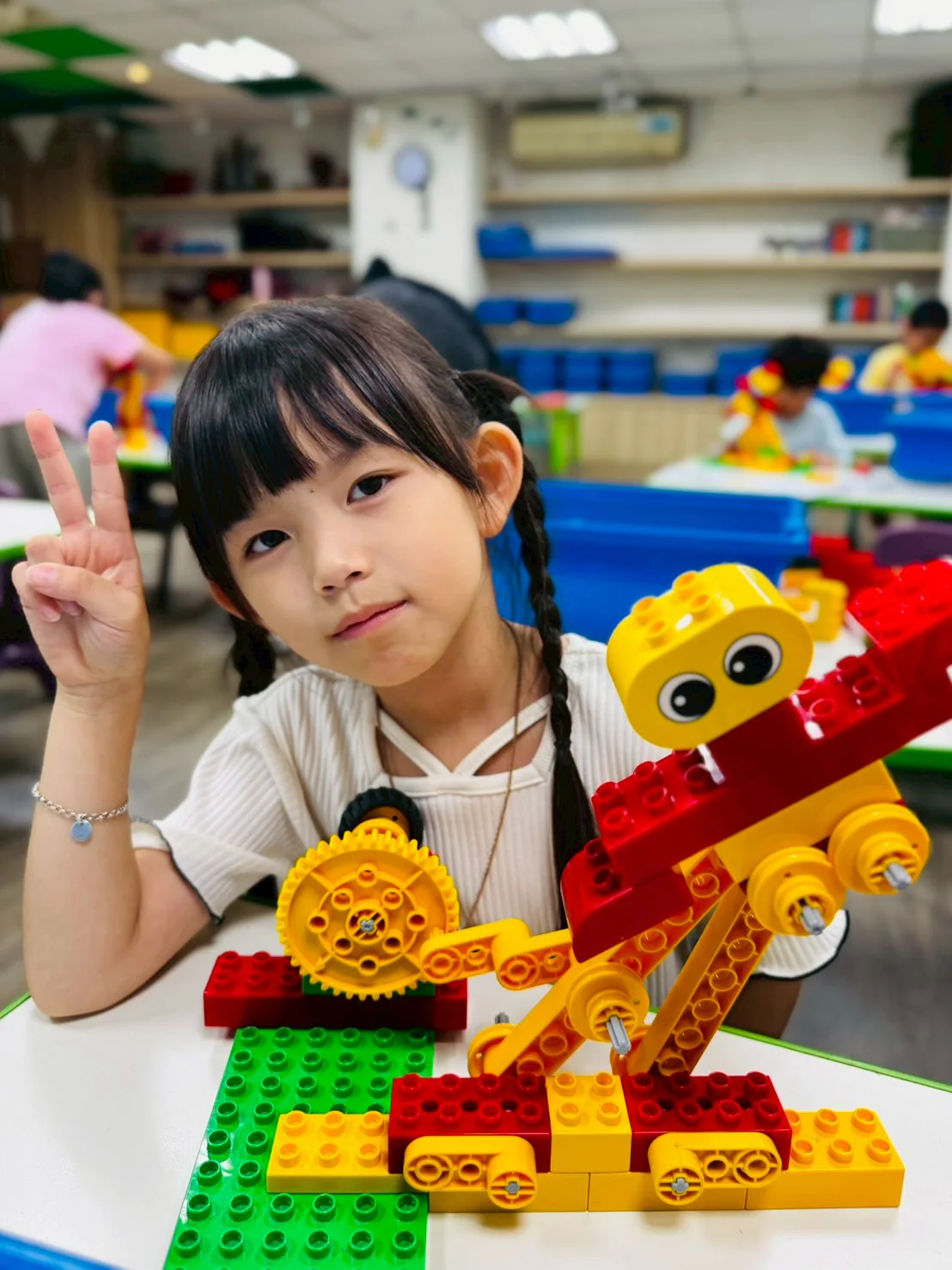An ESM student proudly presenting the gears on a LEGO Dancer model