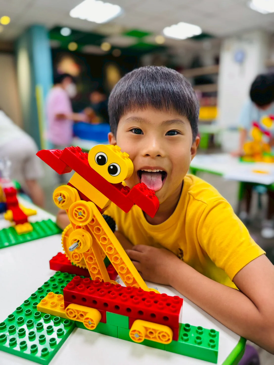 A young engineer posing beside a working LEGO Dancer model
