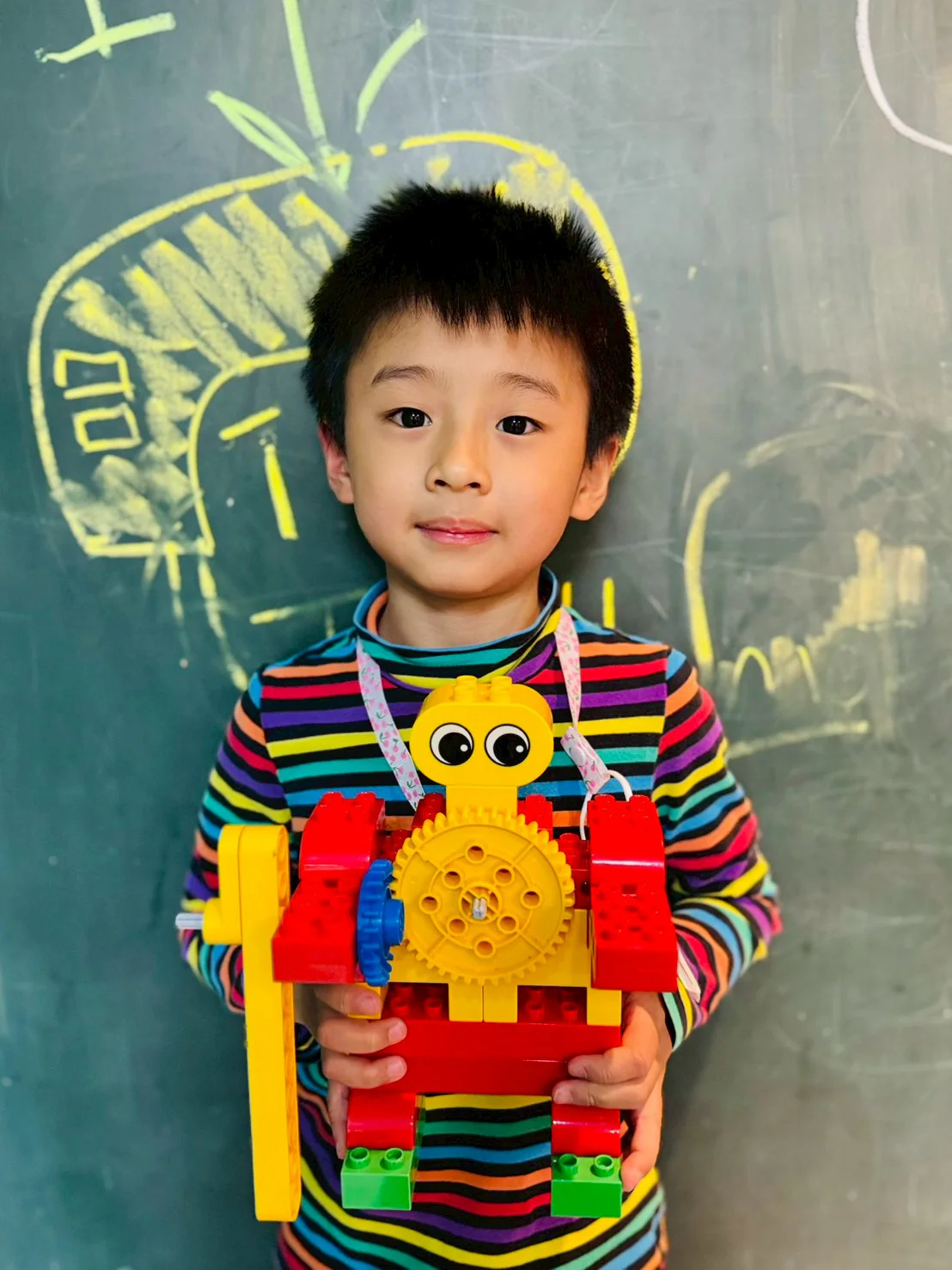 An ESM student holding a LEGO Hockey Player with a large visible gear