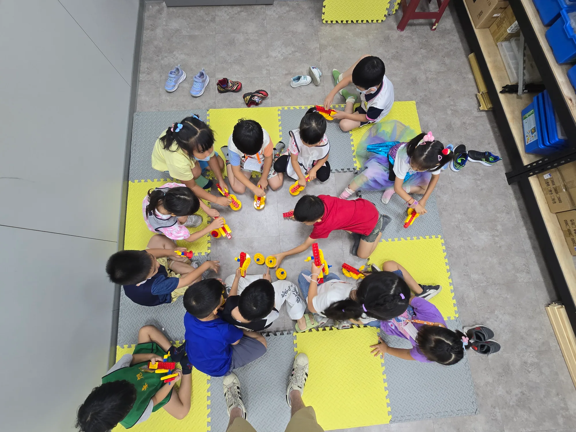 An overhead view of children building LEGO mechanisms together